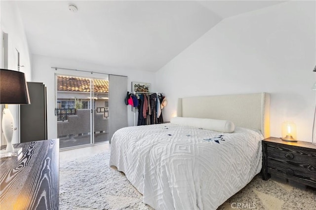 bedroom featuring vaulted ceiling, wood finished floors, and access to exterior