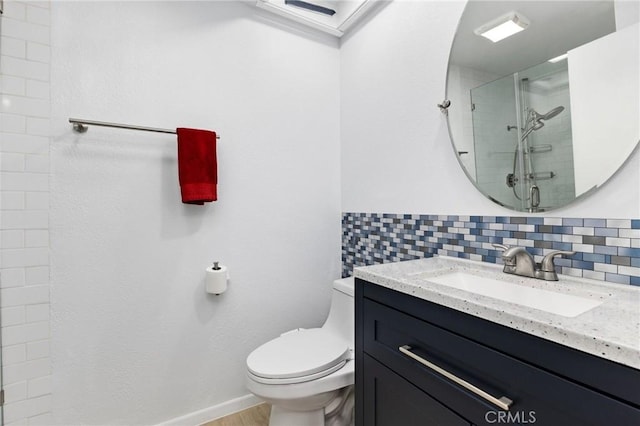 bathroom with backsplash, toilet, a tile shower, vanity, and wood finished floors