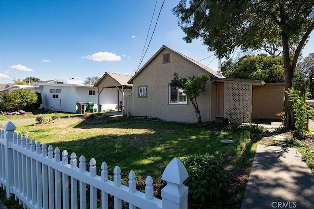 view of front of property featuring fence private yard, stucco siding, and a front yard