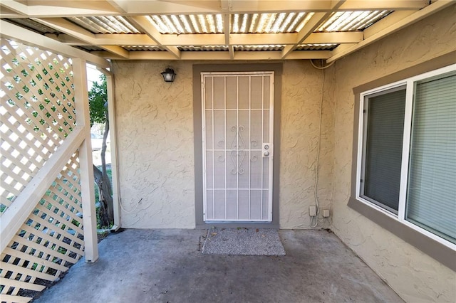 doorway to property featuring stucco siding