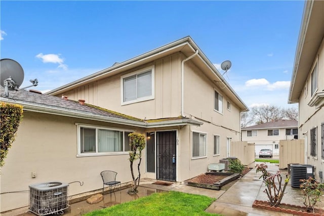 view of front of property with a patio area, stucco siding, and central AC unit