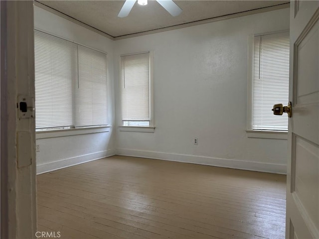 unfurnished room featuring baseboards, ceiling fan, and hardwood / wood-style floors