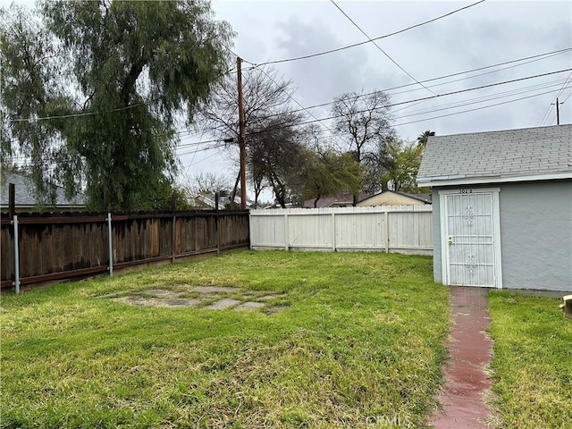 view of yard featuring a fenced backyard and an outdoor structure