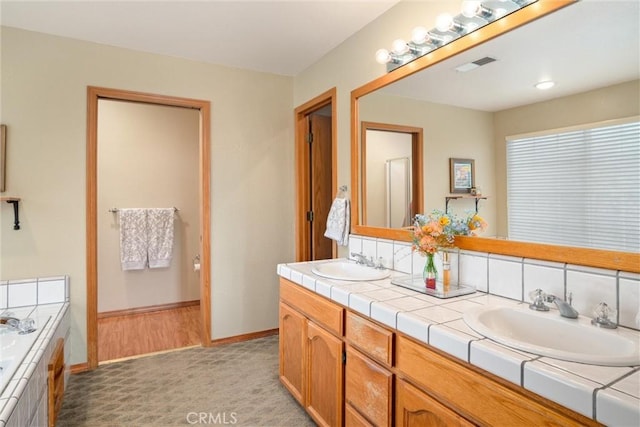 full bathroom featuring double vanity, visible vents, a sink, and a bath