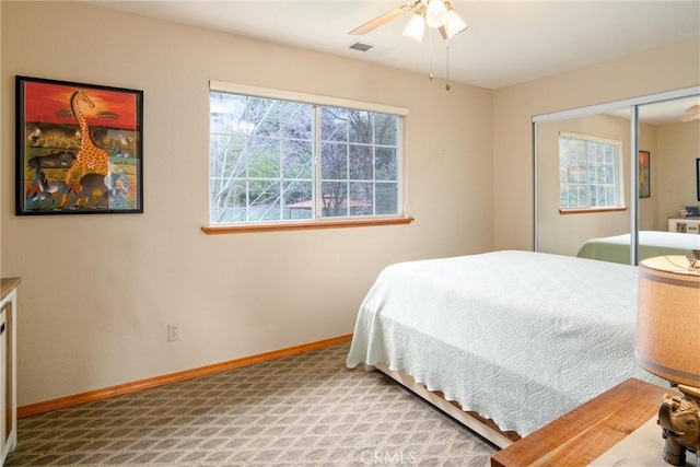 carpeted bedroom with ceiling fan, multiple windows, a closet, and baseboards