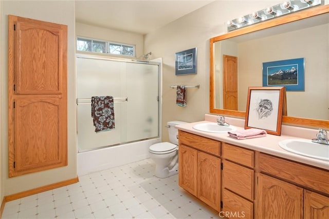 full bath featuring double vanity, a sink, toilet, and tile patterned floors