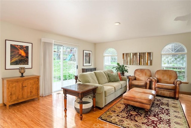 living room with visible vents, light wood-style flooring, and baseboards