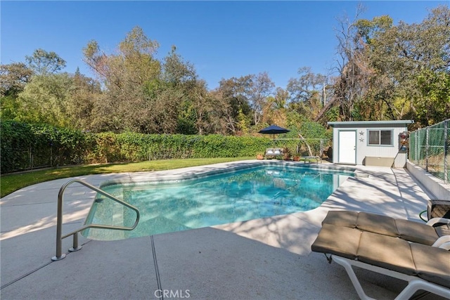 view of swimming pool featuring fence, an outbuilding, a fenced in pool, and a patio