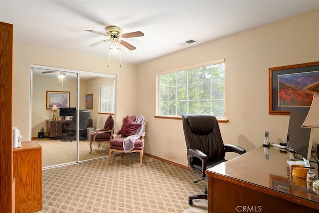 home office with ceiling fan, baseboards, visible vents, and light colored carpet