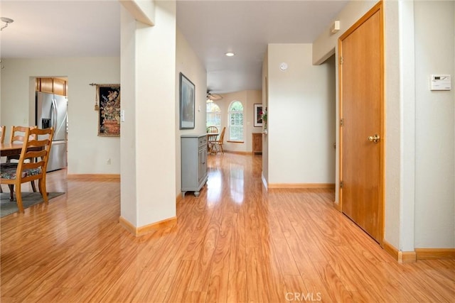 corridor with light wood finished floors and baseboards