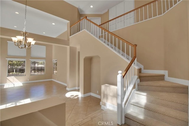 stairs featuring a chandelier, a high ceiling, tile patterned floors, and baseboards