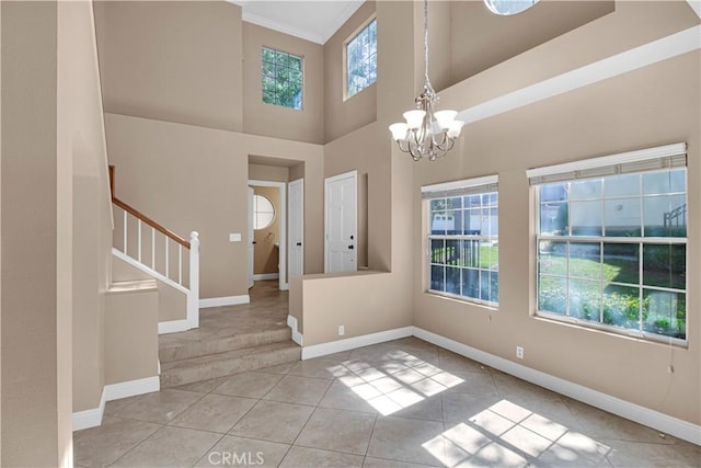 entrance foyer with a chandelier, baseboards, and stairs