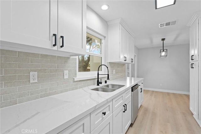 kitchen with visible vents, light wood-style flooring, stainless steel dishwasher, white cabinets, and a sink