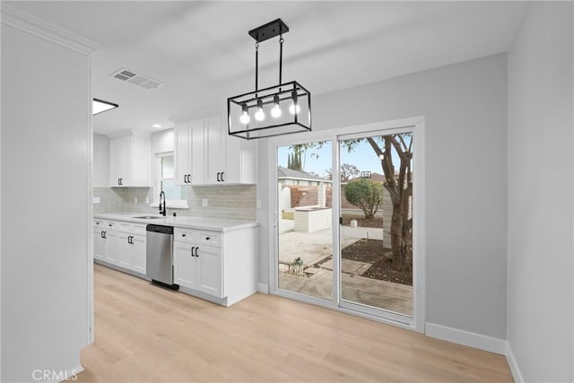 kitchen featuring tasteful backsplash, light countertops, visible vents, a sink, and dishwasher