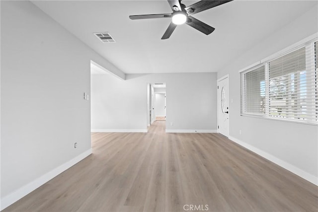 unfurnished living room with light wood finished floors, baseboards, visible vents, and ceiling fan