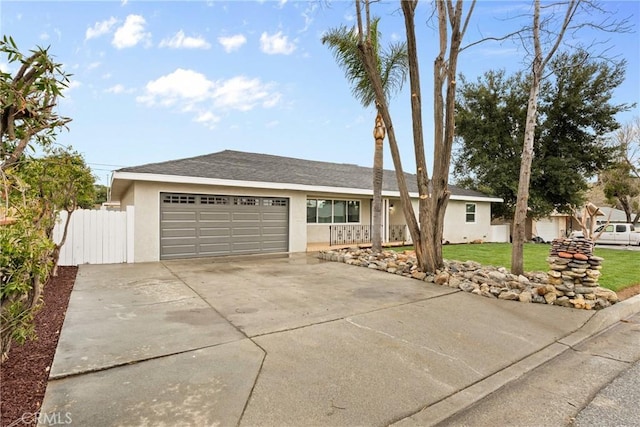 single story home with a garage, driveway, stucco siding, fence, and a front yard