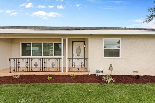 property entrance featuring crawl space, covered porch, a lawn, and stucco siding