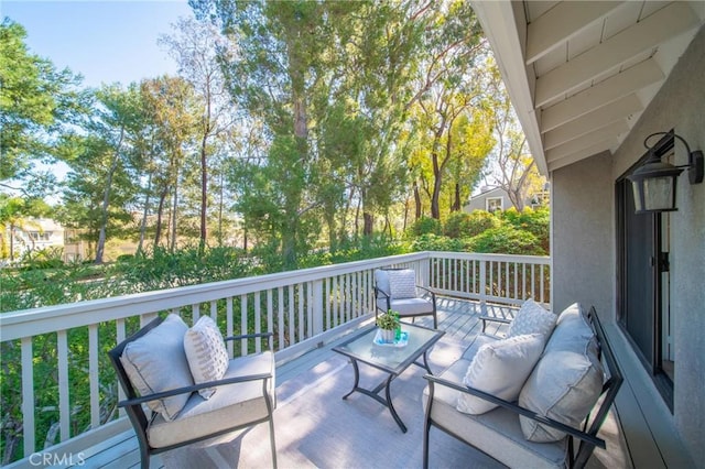 view of wooden balcony with a wooden deck and an outdoor living space