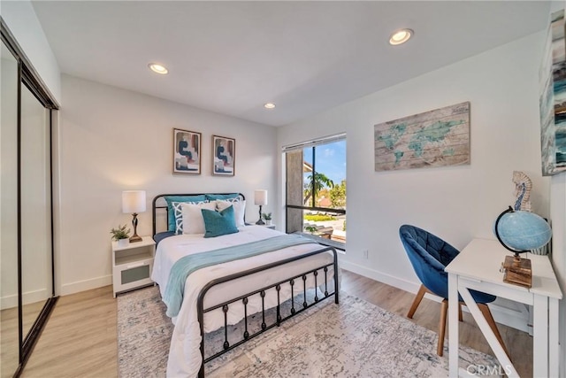 bedroom featuring light wood-type flooring, baseboards, a closet, and recessed lighting