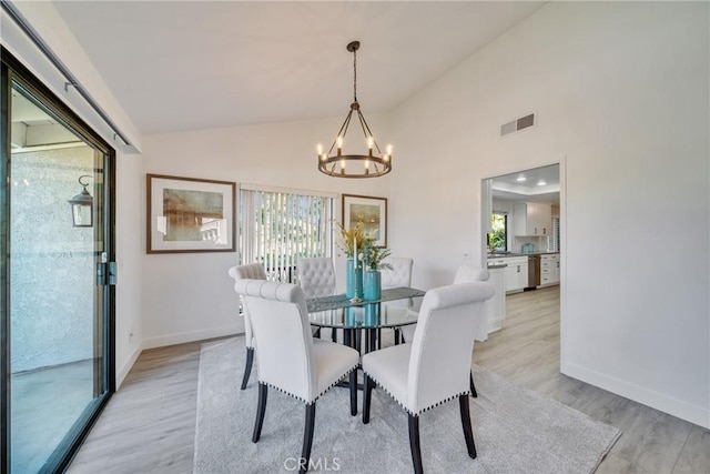 dining room featuring a healthy amount of sunlight, light wood-style floors, visible vents, and a notable chandelier