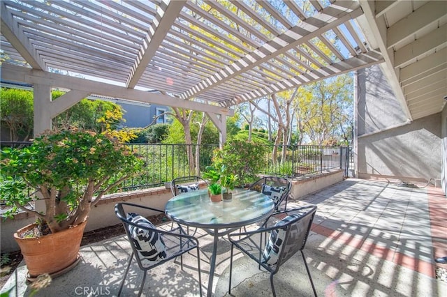 view of patio with outdoor dining space, fence, and a pergola