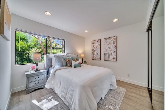 bedroom with recessed lighting, baseboards, and light wood finished floors