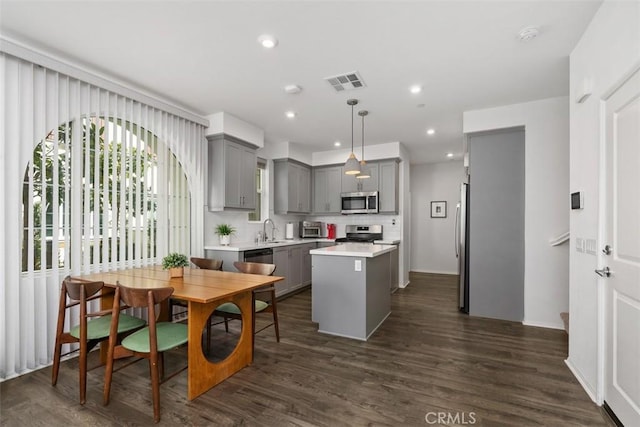 kitchen featuring a center island, gray cabinets, visible vents, light countertops, and appliances with stainless steel finishes