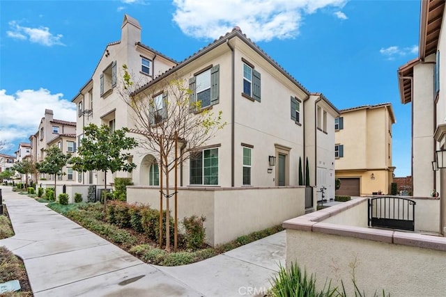 view of building exterior featuring a fenced front yard and a residential view