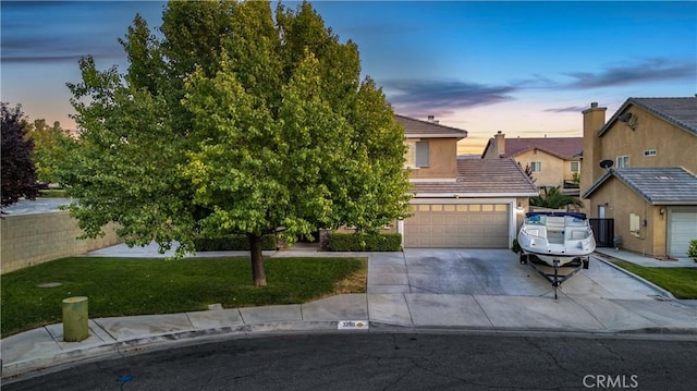 obstructed view of property with an attached garage, concrete driveway, a tiled roof, stucco siding, and a front yard