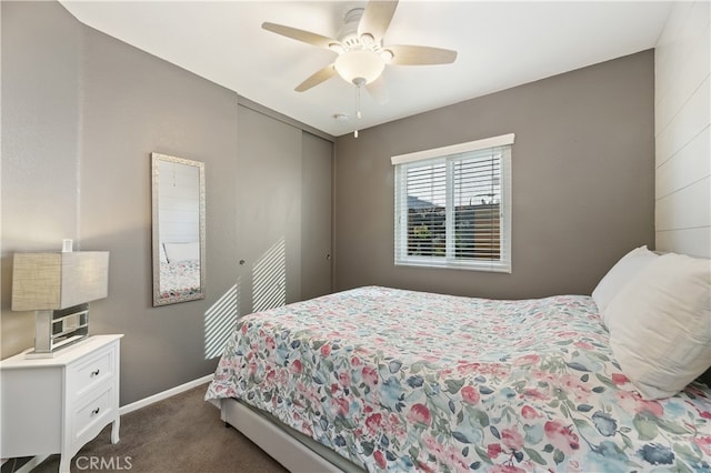 bedroom featuring ceiling fan, a closet, dark carpet, and baseboards