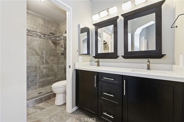 full bath featuring double vanity, a stall shower, a sink, and toilet