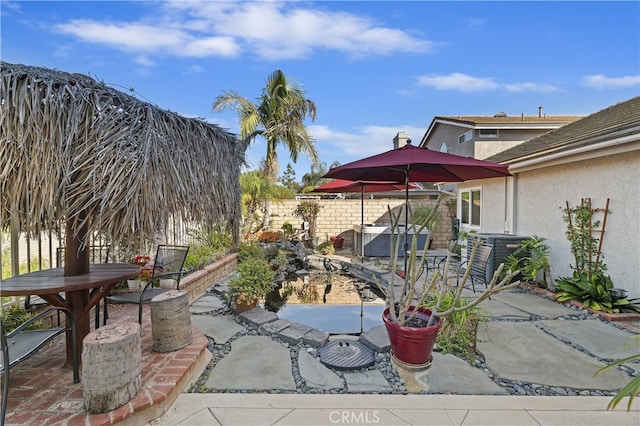 view of patio featuring fence, outdoor dining area, and central AC