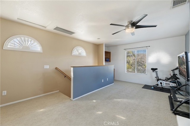 interior space with carpet floors, visible vents, and a ceiling fan