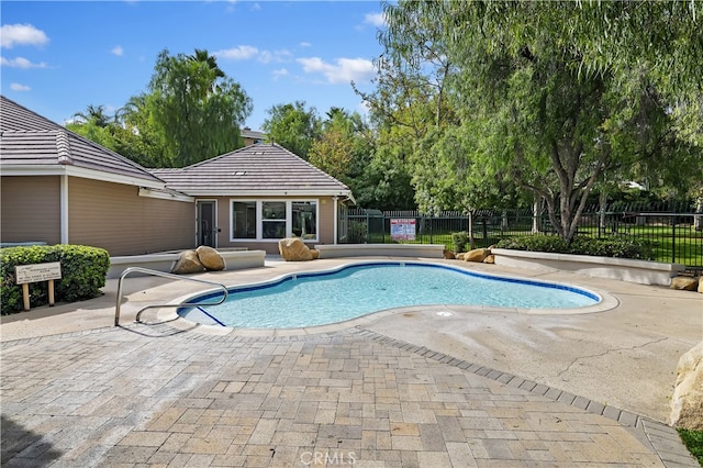 pool featuring fence and a patio