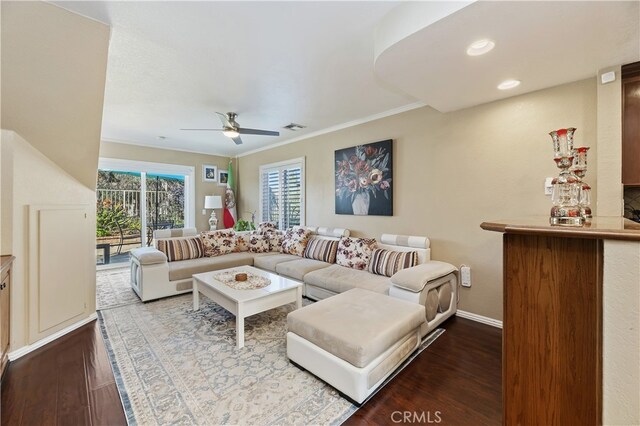 living room featuring visible vents, a ceiling fan, ornamental molding, wood finished floors, and baseboards