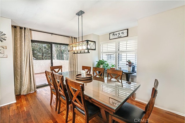 dining space featuring wood finished floors and baseboards