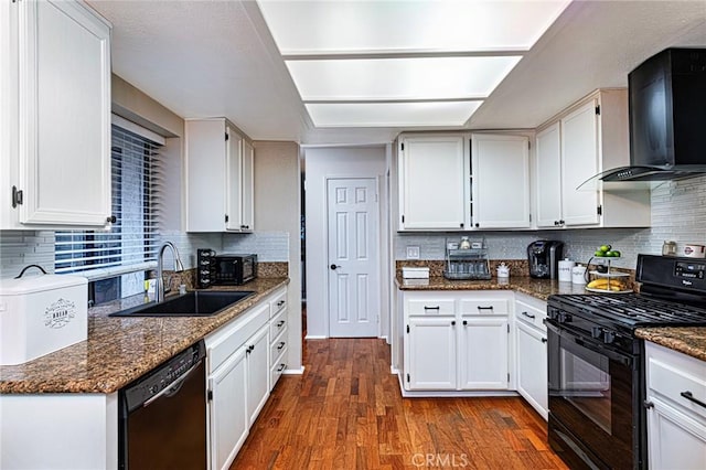 kitchen with decorative backsplash, wall chimney range hood, dark wood-type flooring, black appliances, and a sink