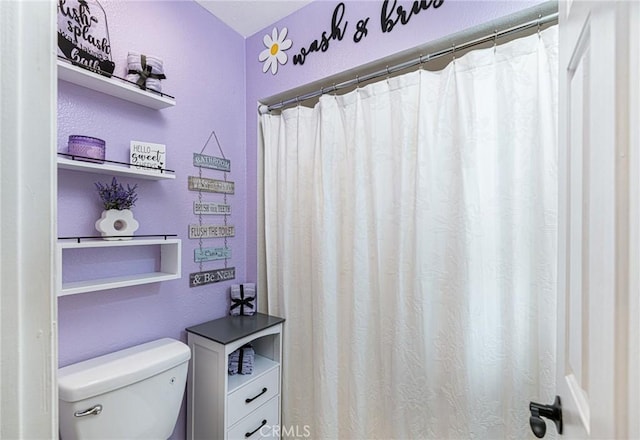 full bath featuring a shower with shower curtain and toilet