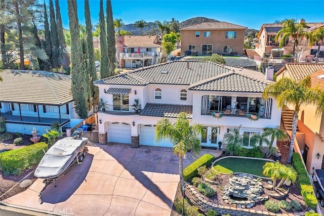 exterior space with a tiled roof, french doors, driveway, a balcony, and an attached garage