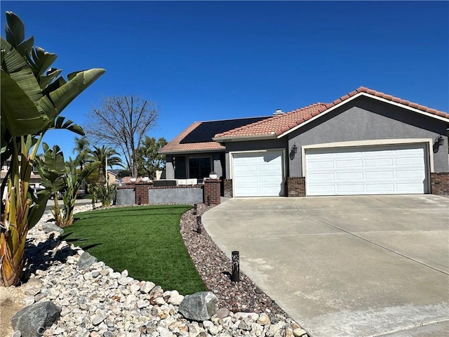 view of front facade with stucco siding, concrete driveway, a garage, a tiled roof, and roof mounted solar panels