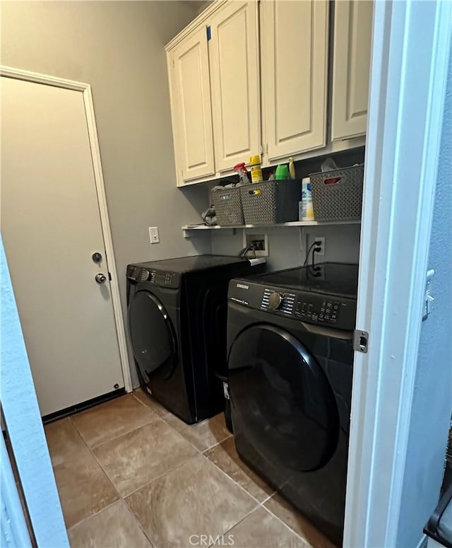 laundry room featuring washing machine and dryer, light tile patterned floors, and cabinet space