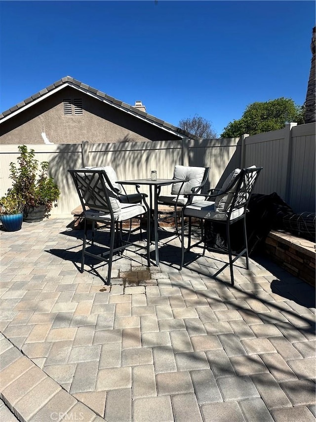 view of patio with outdoor dining space and fence