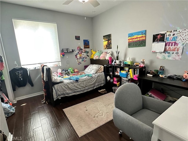 bedroom with a ceiling fan, wood finished floors, and baseboards