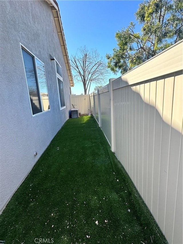 view of yard with central AC unit and a fenced backyard