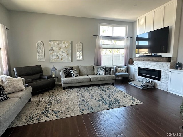 living room with a high ceiling, a fireplace, and dark wood-style flooring