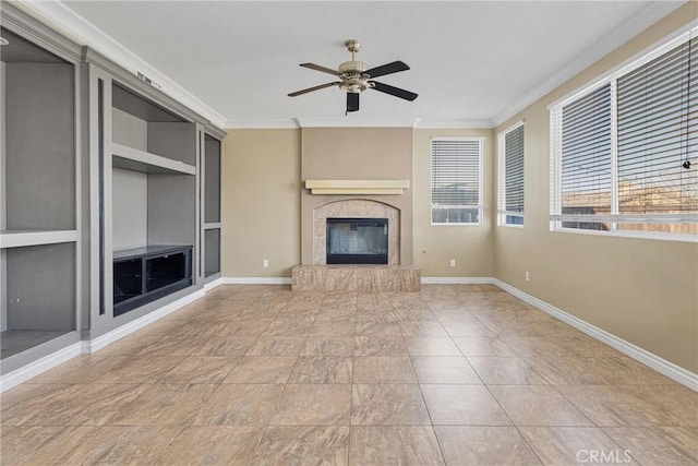 unfurnished living room with built in features, a glass covered fireplace, crown molding, and baseboards