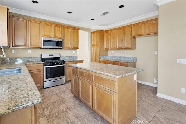 kitchen featuring stainless steel appliances, a sink, visible vents, a center island, and crown molding