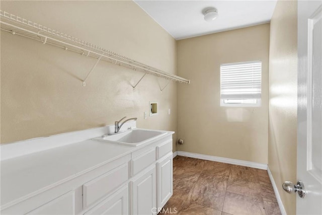 clothes washing area with washer hookup, a sink, and baseboards