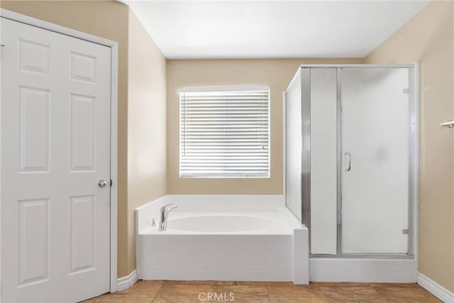 bathroom featuring tile patterned flooring, a shower stall, and a bath