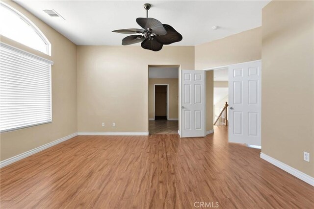 unfurnished room featuring ceiling fan, baseboards, visible vents, and light wood-style floors